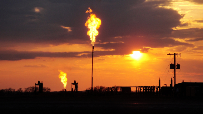 Methane flares burn at sunset in the Bakken oil and gas fields in North Dakota in this 2014 photo. 