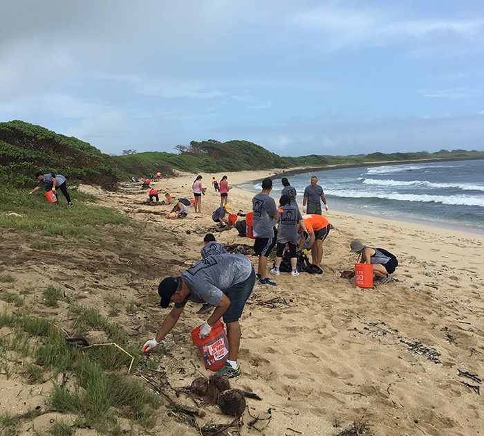 Volunteers clean up debris from a Hawaiian beach during a 2016 ICC event. 