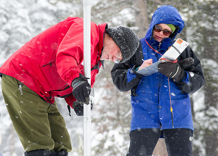 Frank Gehrke, left, of the California Department of Water Resources, measures snow levels in the mountains of El Dorado County, California. 