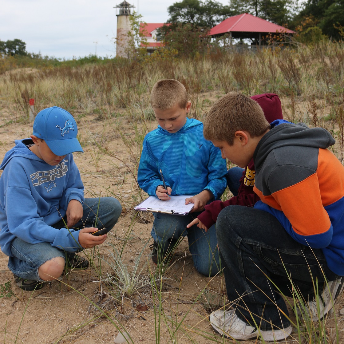 Students use tablets and GPS units while working with Michigan Sea Grant and Michigan Natural Features Inventory ecologists to map federally threatened species in coastal dune environments on Charity Island.