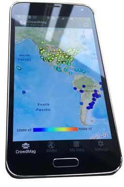 A cell phone portraying the CrowdMag app on the screen. A map is shown of North and South America with different-colored dots suggesting data points.
