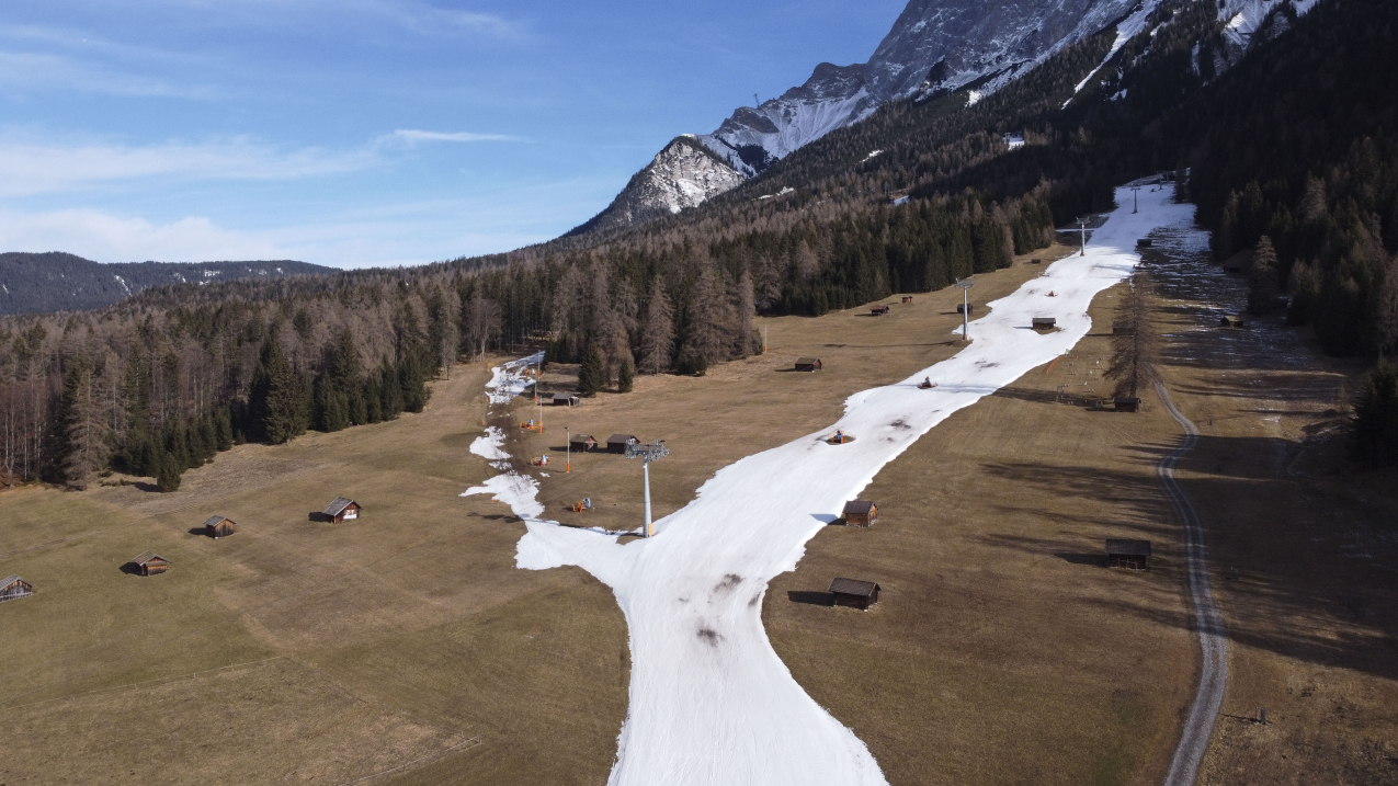 An aerial view shows a closed slope of artificial snow below Zugspitze mountain on January 16, 2023, near Ehrwald, Austria.