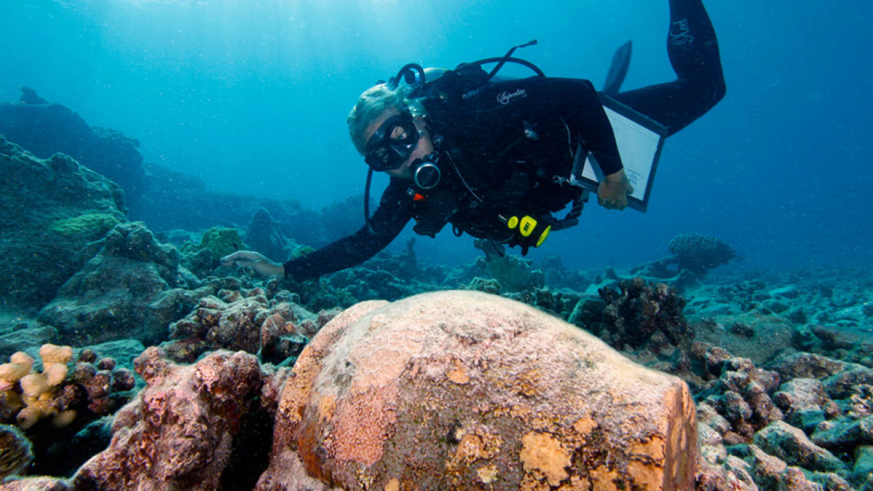 Dr. Kelly Gleason investigates a ginger jar at the Two Brothers shipwreck site at French Frigate Shoals. 
