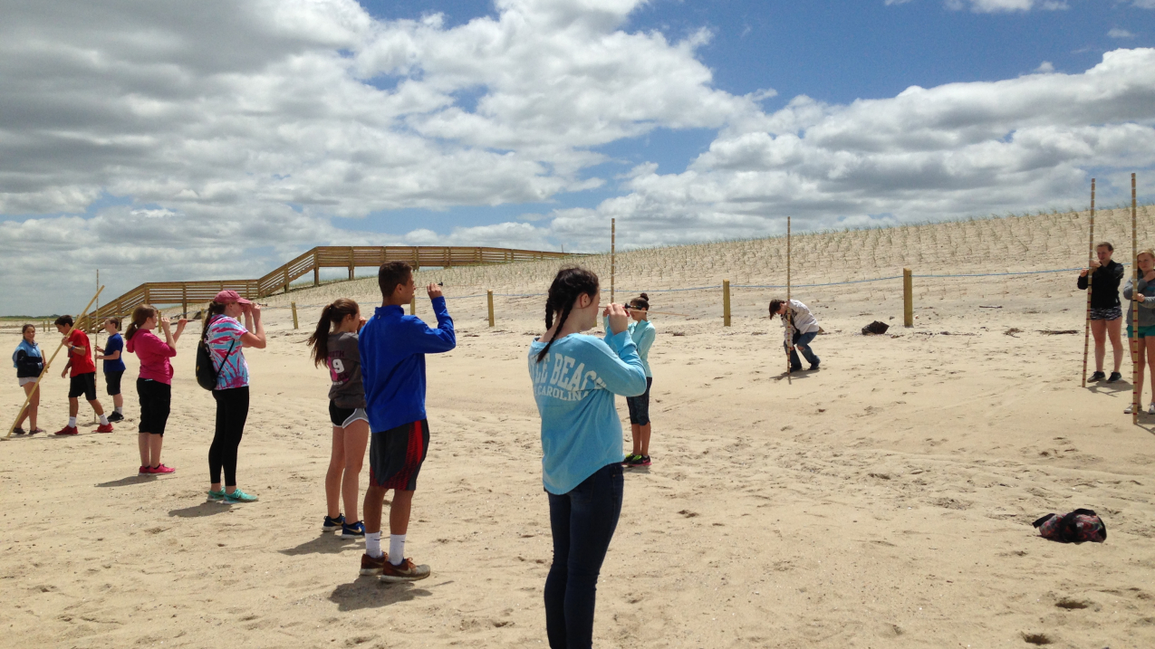 STEM Academy Middle School 8th grade students using measuring poles and levels to determine the location of the hypothetical high tide line given projected one and two meter increases in sea level to their local beach on Cape Cod.