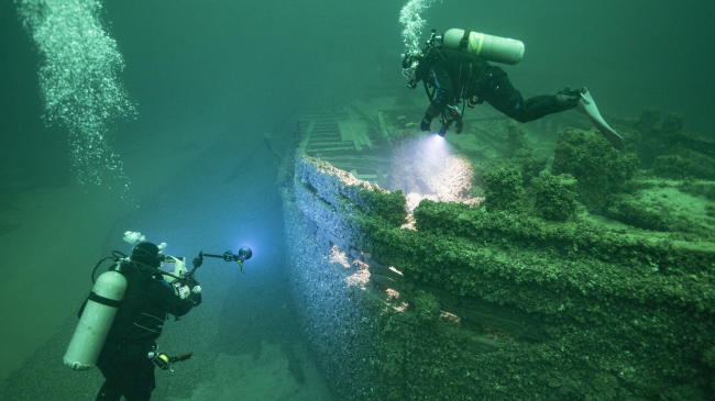 Divers examine the Great Lakes schooner St. Peter, which was carrying coal when it sank in a storm in 1898.