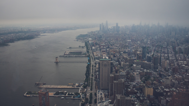 Aerial view of the Hudson River in New York City showing the area engulfed in grey smog.