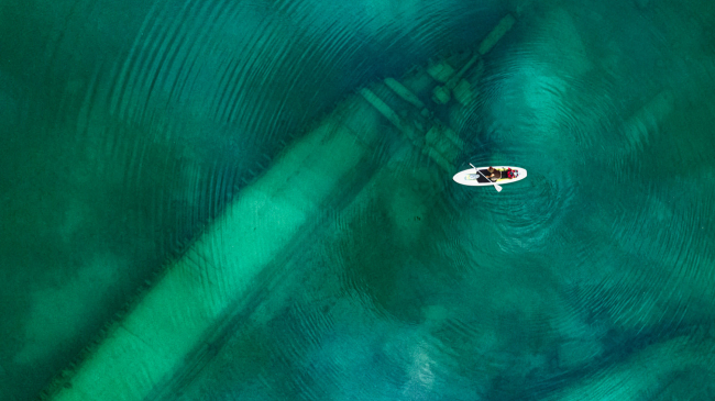 A person kayaks over a shipwreck within Thunder Bay National Marine Sanctuary