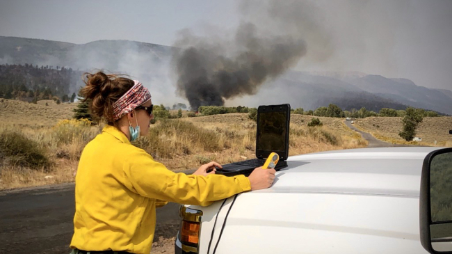 Since 1914, NOAA meteorologists have worked closely with fire behavior experts from the Forest Service, the Bureau of Land Management; and other federal, state, and local fire control agencies that are responsible for suppressing fires. IMETs, such as NWS Boulder Meteorologist Lisa Kriederman (shown here at the East Fork, Utah, fire in September 2020), work alongside fire managers, providing weather forecasts and meteorological support to help them develop strategies for fighting and controlling wildfires.