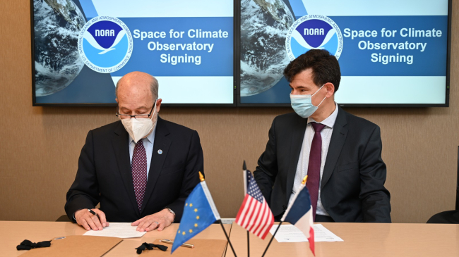 NOAA Administrator Dr. Rick Spinrad (L) signs the Space for Climate Observatory charter, as Philippe Baptiste, Ph.D., Chairman and CEO of the French National Center for Space Studies (CNES) looks on.
