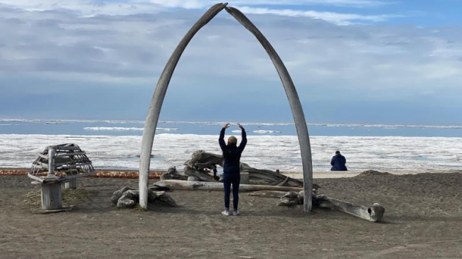 Mabel Baldwin-Schaeffer, tribal research coordinator, stands under whale bones in Utqiagvik, Alaska.
