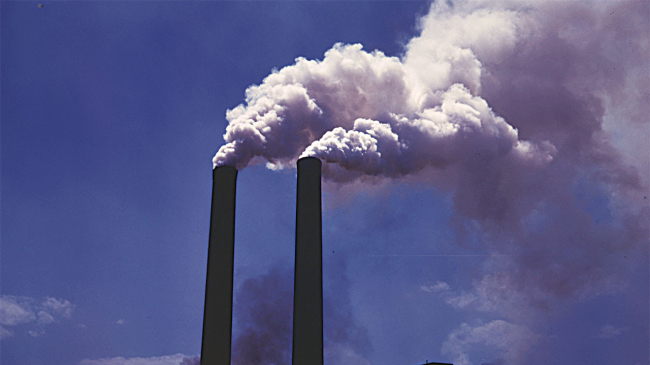 Thick smoke from a coking plant being emitted from the top of two stacks. Undated image.