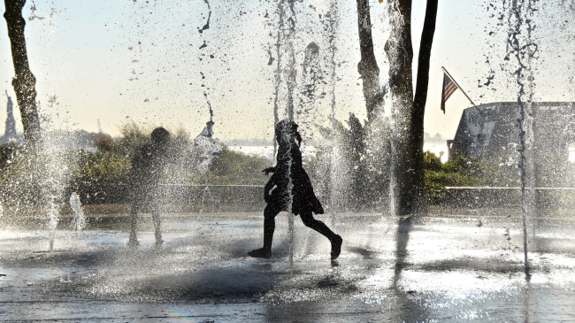 Children playing in water fountain.