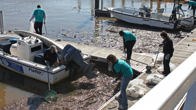 Photos showing volunteers at the Anacostia River Watershed annual cleanup in Washington, D.C. metro area  fish out marine debris from the river's waterfront.