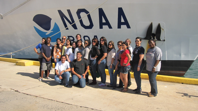AEROSE team posing about the NOAA vessel Ronald H. Brown include Vernon Morris, far right, and Everette Morris, third from right, both of NCAS at Howard University ,and NOAA scientist Claudia Schmid, front row, green jacket.