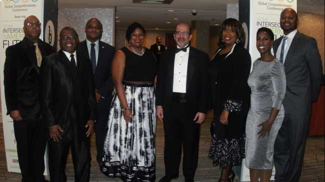 From left to right, NOAA employees From left to right are Kenneth Bailey, Salim Abddeen, Dr. Lonnie Gonsalves, Dr. Jamese Sims, Ben Friedman, Dr. Kandis Boyd, Jennifer Dickens, and Dr. DaNa Carlis in formal evening wear. They are standing in front of an entryway for BEYA marked Career Fair.