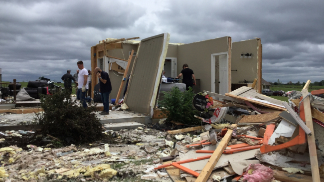 People survey the heavy damage to a home west of Bonner Springs, Kansas, from an EF-2 tornado that occurred May 28, 2019. 