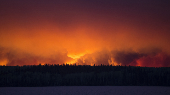 A massive wildfire rages Wednesday evening, May 4, 2016, near Fort McMurray. 