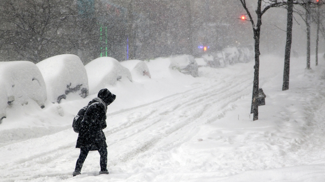 A person treks down a street filled with snow during a heavy winter storm that hit the Bronx, New York. (Undated image).