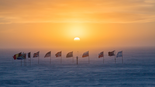 The sun goes down at the South Pole: The last light of autumn (March 20, 2018) bathes an array of flags from the 12 nations that were the original signatories on the 1959 Antarctic Treaty who pledged that they would pursue non-military, cooperative scientific research. 