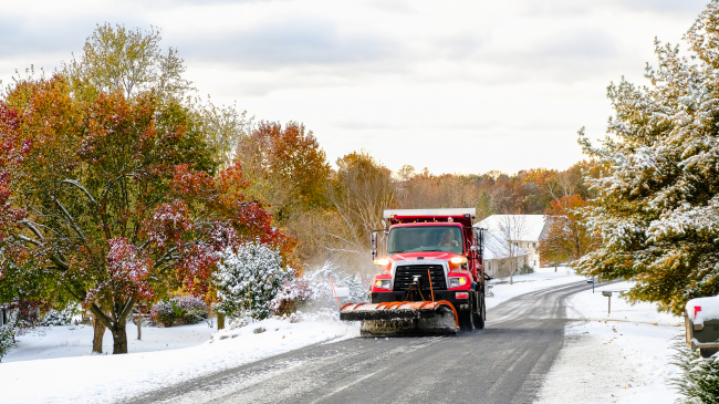A first autumn snowfall: A snowplow-fitted truck heads down a local road in Missouri. Undated stock image.