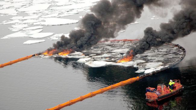 Responding to oil spills in the ice-covered Arctic Ocean would pose unique challenges. For example, floating booms often used to concentrate oil for burning — as in this field experiment in the Barents Sea — must be strong enough to handle increased drag from ice floes. (Undated image.)