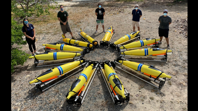NOAA partners from the Cooperative Institute for Marine and Atmospheric Studies at University of Miami and the Caribbean Region Association for Coastal Ocean Observing gather around 11 ocean gliders that will track hurricane data off Puerto Rico, July 14, 2020. 