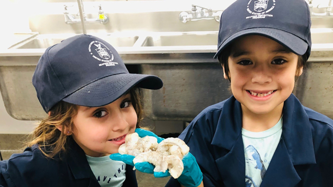 Kids visiting NOAA’s seafood inspection lab in Long Beach, California, learn how to inspect shrimp for quality, freshness and safety.