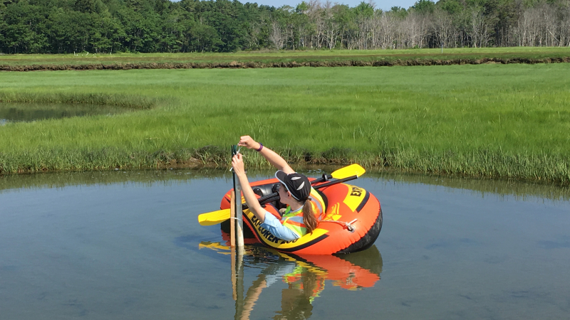 Megan Gillen, a 2018 NOAA Hollings scholar, deploys an InSitu AquaTroll sensor during a fieldwork day in the Little River Marsh at the Wells National Estuarine Research Reserve in Wells, Maine. Some of these pools were so large that she had to float herself out using an inflatable raft! In this image, she is attaching the AquaTroll to a field stand she constructed to house the sensor over the deployment period.
