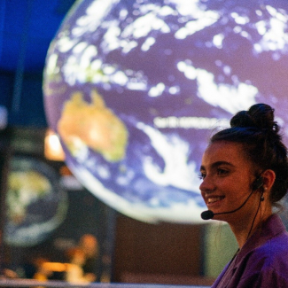 Malgorzata Gasienica-Bednarz, a high school student, talks about acid rain using the Science on a Sphere six-foot-diameter globe at the Museum of Science and Industry in November 2019. 