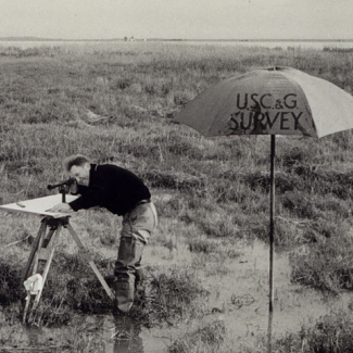 Until the 1990s, an alidade, or telescope-like instrument, was used along with a plane table to manually map features such as those in this coastal marsh. Sensors on drones now do this work efficiently, cost-effectively and with greater precision.  