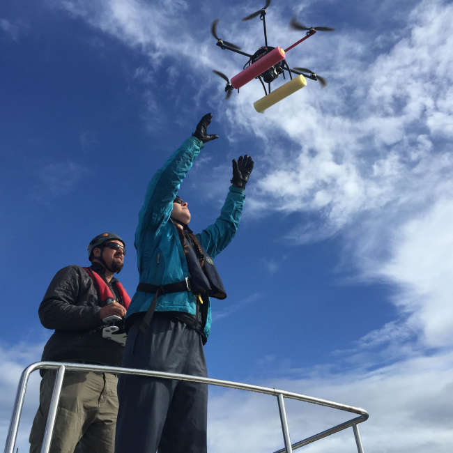 NOAA's John Durban and Holly Fearnbach release a hexacopter to photograph and gather breath samples from whales.