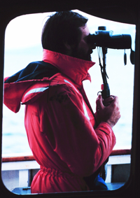 A marine mammal observer at work on the JOHN N. COBB ship