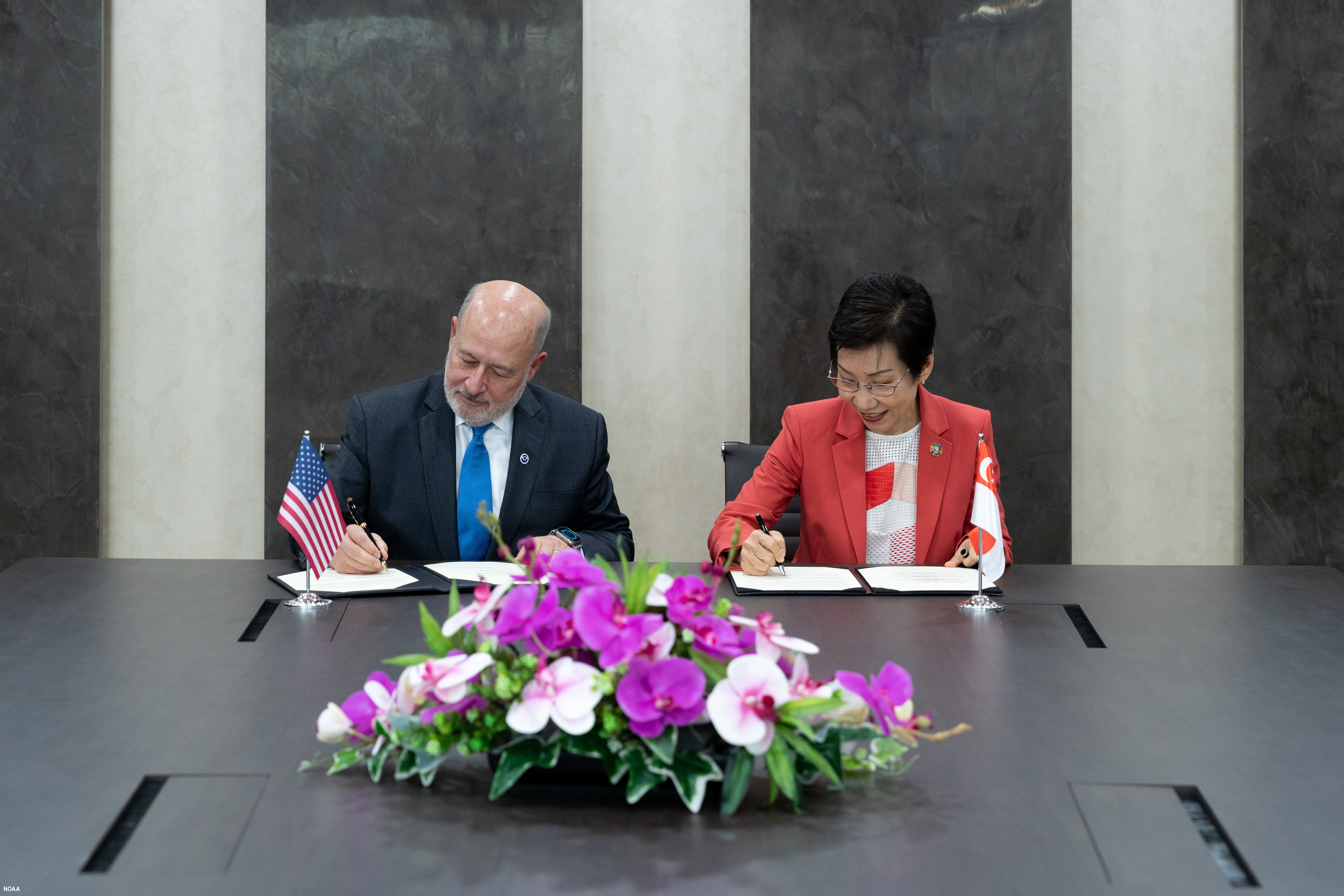 Photo showing Under Secretary of Commerce for Oceans and Atmosphere and NOAA Administrator Rick Spinrad, Ph.D. and Singapore Minister for Sustainability and the Environment and Minister-in-charge of Trade Relations Ms. Grace Fu signing an MOU to enhance bilateral cooperation on environmental management and climate protection in Singapore on April 15, 2024.  (Image credit: NOAA)