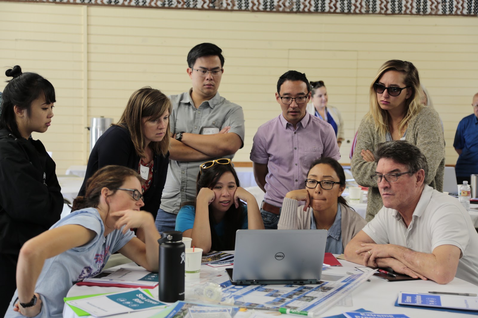Participants from the Bishop Museum in Honolulu, HI, gather around a laptop to see the visualization of their resilience plan. Using Google Earth visualizations allowed participants to explore how their climate resilience plans affected the city on a local level.
