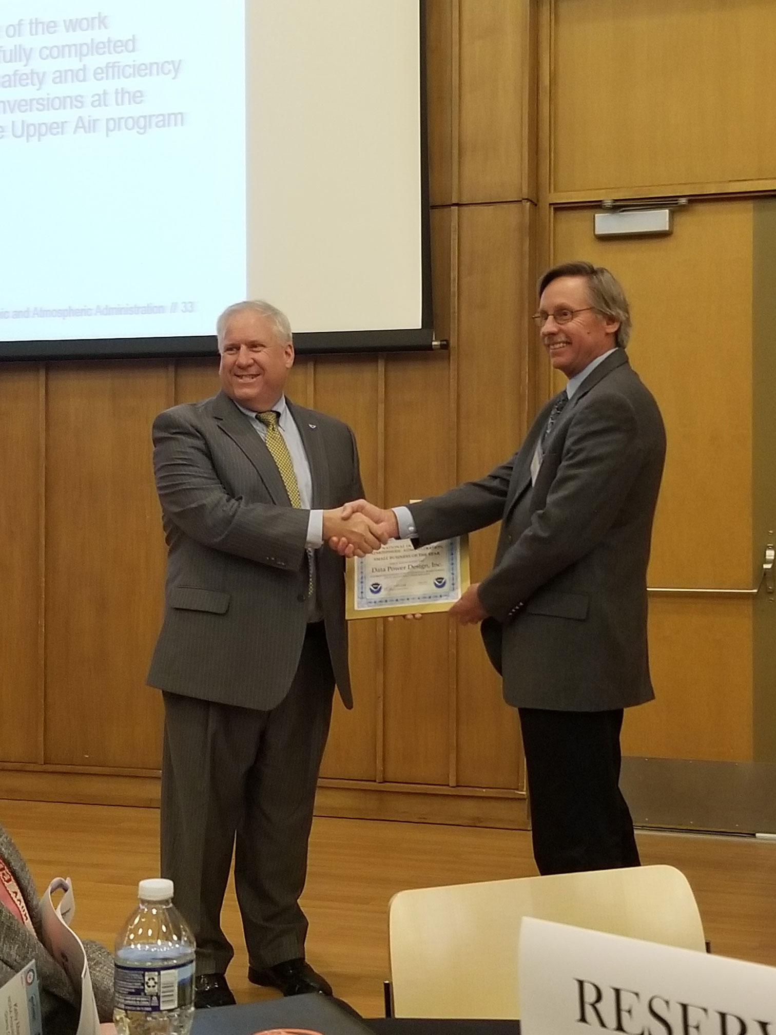 Data Power Design, Inc. (DPDI) President John Nellenback receives the Small Business of the Year Award from AGO Director Jeffrey Thomas at NOAA’s Small Business Industry Day, April 4, 2019