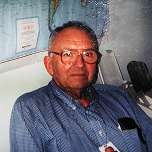 A photo of Clyde MacKenzie, Jr. in a blue button-down shirt, looking to camera.