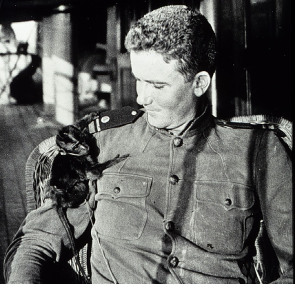 LTJG George L. Anderson aboard the USC&GSS Marinduque, 1924. The monkey sits on his shoulder, as he looks down at it.