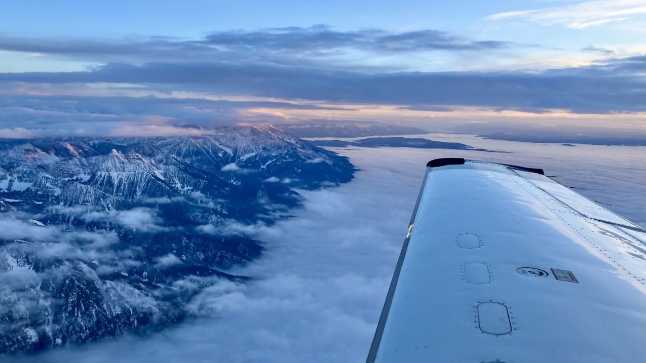 Photo of an  instrumented Mooney research aircraft passes over the Northern Rocky Mountains in Montana during NOAA’s 2023 NOGAP aerial mission to capture atmospheric profiles of greenhouse gases in a series of flights across the United States. Credit: Anna McAuliffe/CIRES.