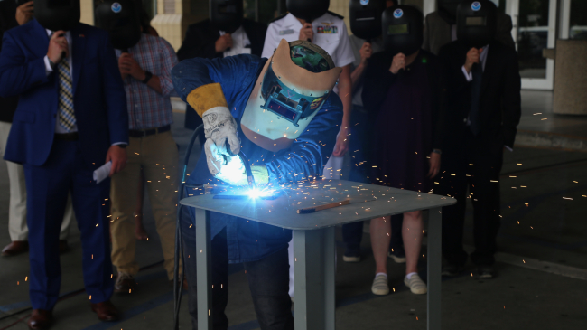 A welder from Thoma-Sea Marine Constructors, LLC, welds the initials of the Oceanographer's sponsor, Linda Kwok Schatz, onto a steel plate that will be incorporated into the ship in keeping with maritime tradition. 