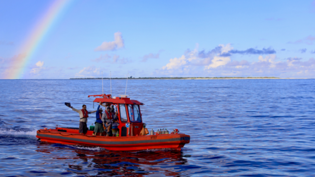 One of the small boats returns to the ship under a rainbow after collecting water samples and deploying instruments around Kure Atoll. 