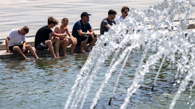 AUGUST 2, 2024: People cool off on the National Mall in Washington, D.C. The D.C. area was under an excessive heat warning that day. Summer 2024 was the fourth-hottest summer on record for the U.S.