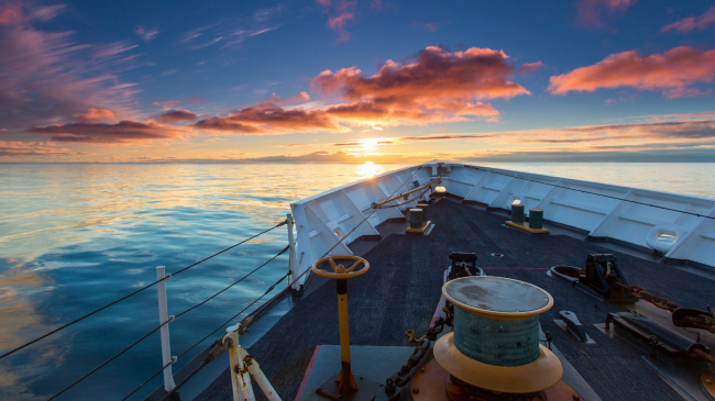 The Coast Guard Cutter Munro from Kodiak, Alaska, sails toward the sunset during an unusually calm evening on the Bering Sea.