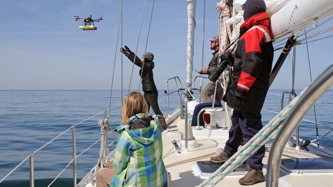 Unmanned aerial systems, such as the 'hexacopter' pictured above, are a powerful new tool for whale research. NOAA's John Durban, center, remotely directs the hexacopter into the outstretched hands of NOAA's Holly Fearnbach.