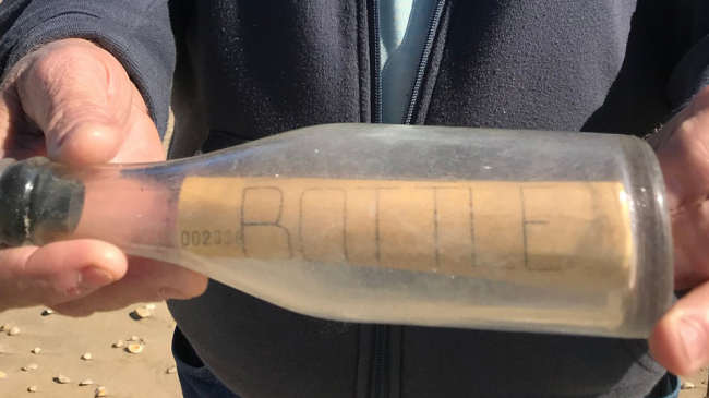 Beachgoer Jim Duke with a science bottle he and wife Candy found along the shore.