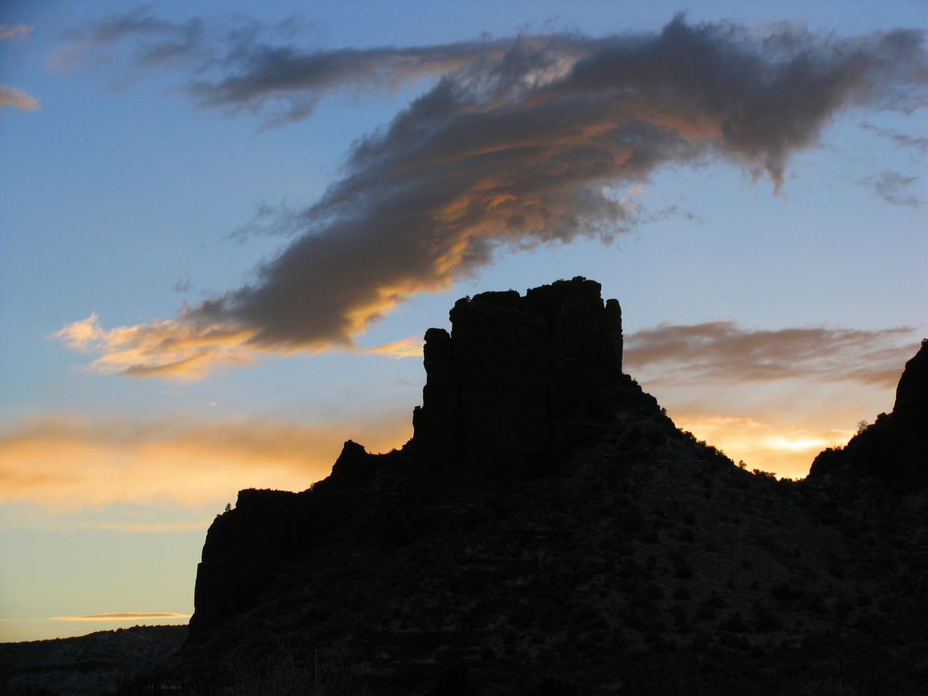A castle-like rock structure silhouetted in the sunset
