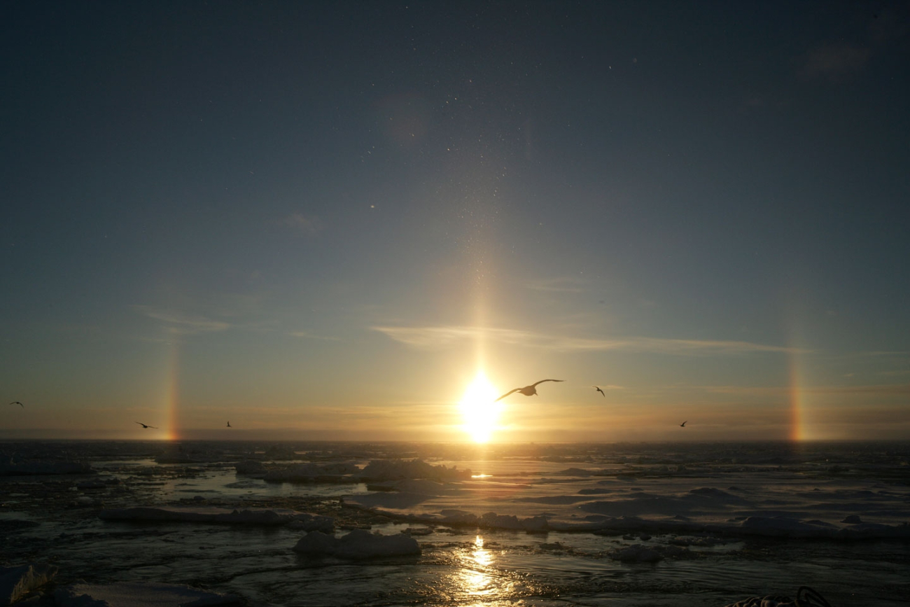 Sun dogs and pillar - atmosphere phenomenom caused by refraction of sunlightthrough ice crystals in the atmosphere