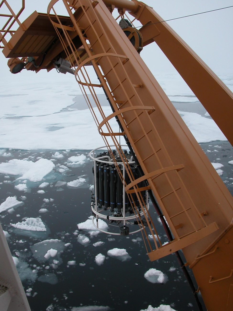 A CTD cast and rosette full of water sampling containers are lowered into icyArctic waters during the NOAA-sponsored cruise to study marine life in theCanada Basin of the Arctic Ocean