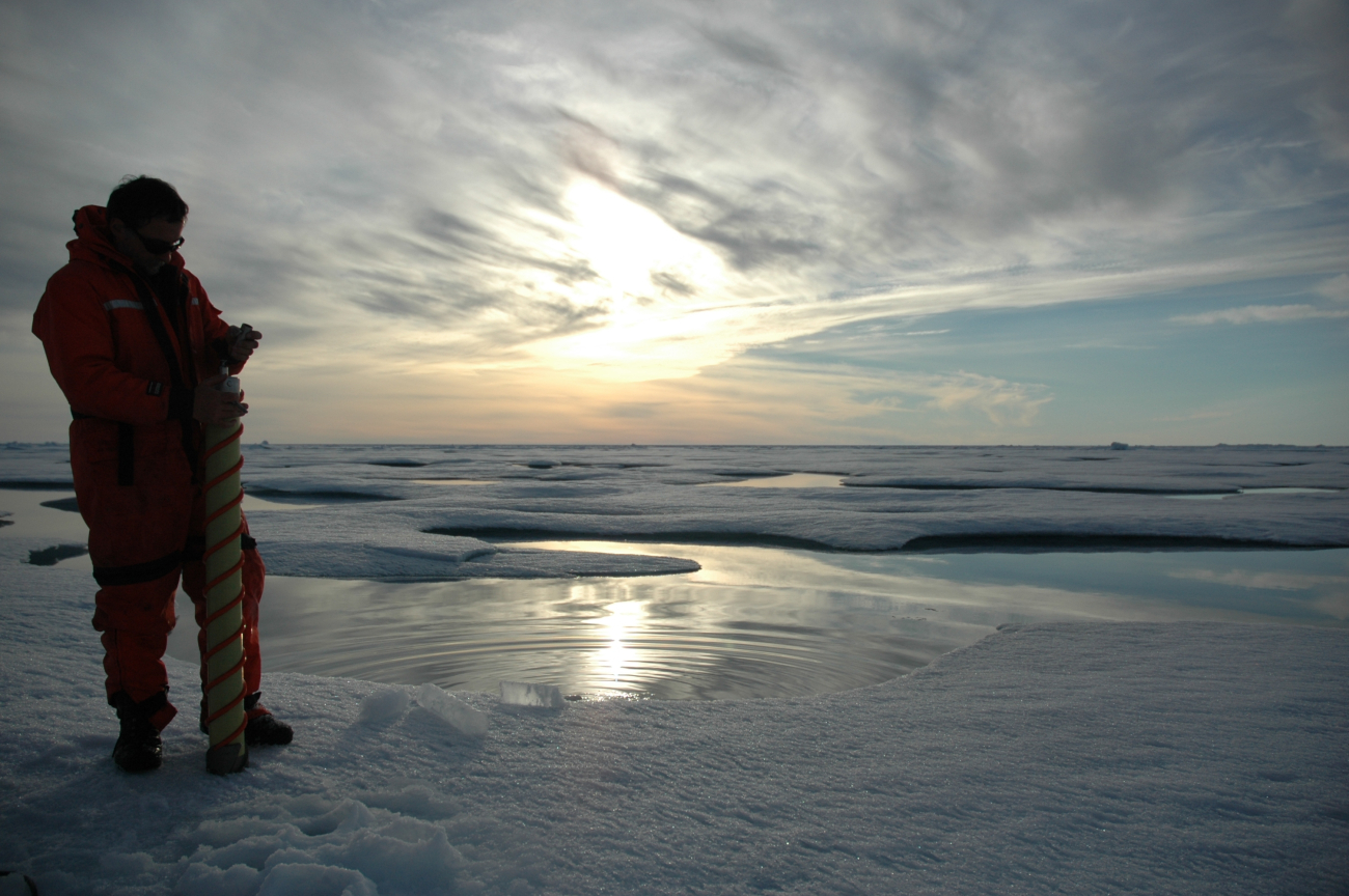 Rolf Gradinger is silhouetted by the Arctic sun while collecting an ice core