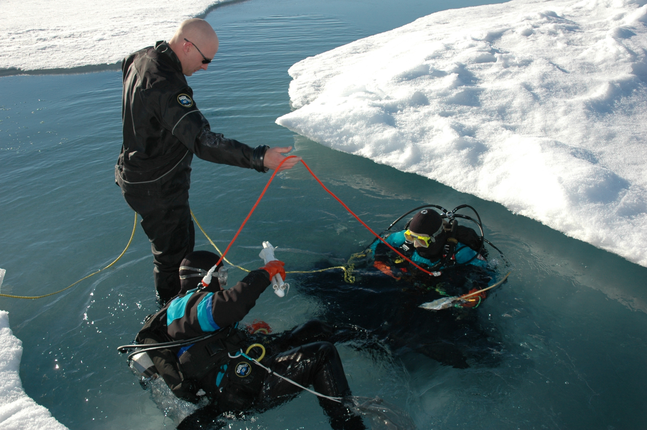 Scientific divers preparing to go under the ice to study ice configuration andlife forms