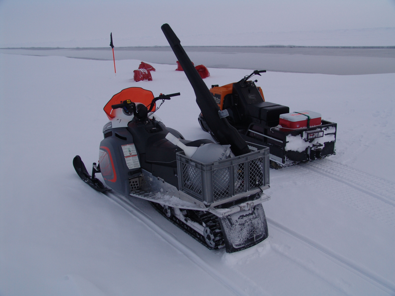 Snow-mobiles used to transport scientists checking sensor array alongopening lead